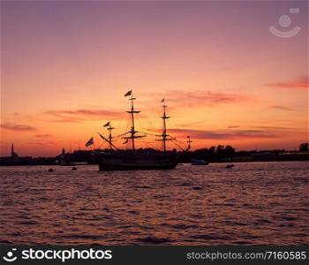 Silhouettes of ships in the waters of the Neva river at sunset. Silhouettes of ships on a sunset background