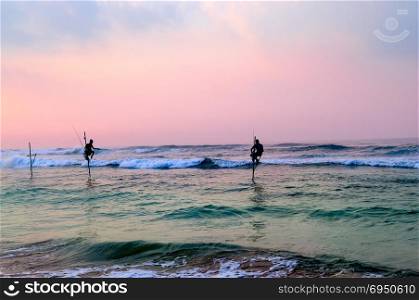 Silhouettes of the traditional stilt fishermen at sunset near Galle in Sri Lanka