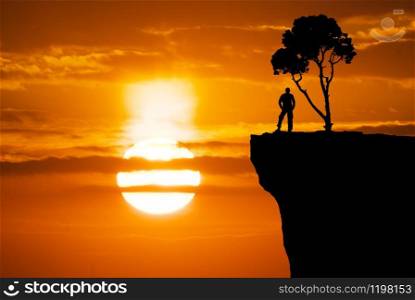 Silhouettes of the trees and man. Beautiful sun and sky. Conceptual scene.