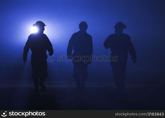 Silhouettes of three workers