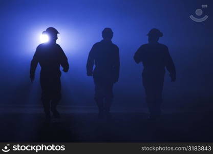 Silhouettes of three workers