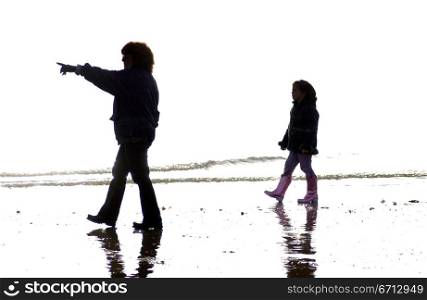 silhouettes of two people on beach