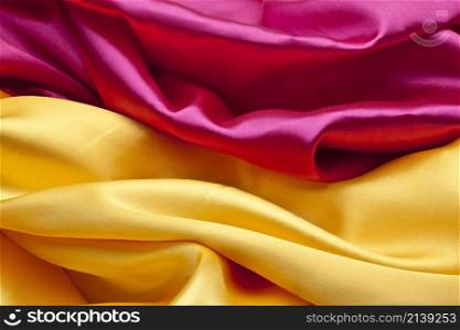 Silk background or texture in pink and yellow colors. Silk background in pink and yellow colors