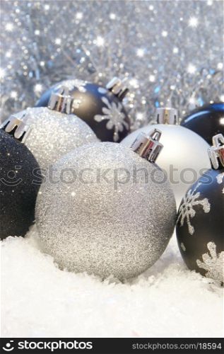 Silver and black Christmas decorations in snow