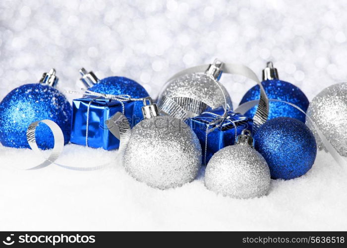 Silver and blue Christmas decorations on snow close-up