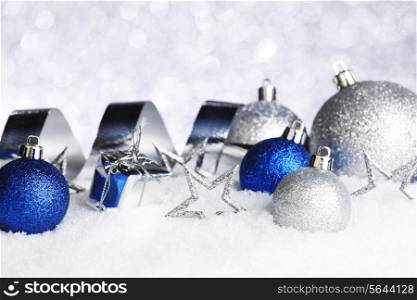 Silver and blue Christmas decorations on snow close-up