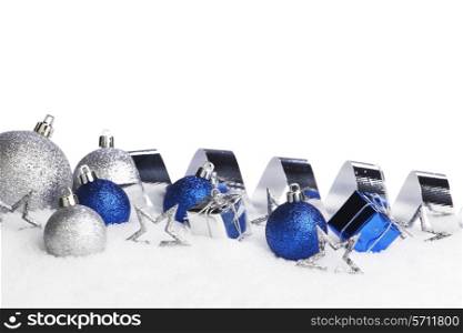 Silver and blue Christmas decorations on snow close-up