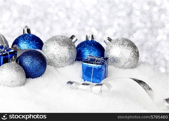 Silver and blue Christmas decorations on snow close-up. Christmas decorations on snow