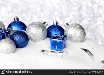Silver and blue Christmas decorations on snow close-up. Christmas decorations on snow