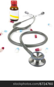 silver and blue stethoscope and colorful pills on white background