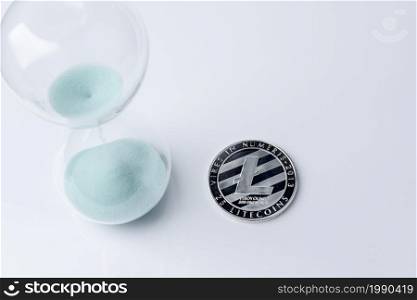 Silver bitcoin and hourglass on a white background. Digital currency.. Silver bitcoin and hourglass on a white background.