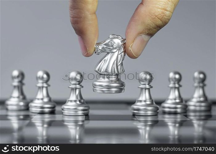 silver Chess knight figure Stand out from the crowd on Chessboard background. Strategy, leadership, business, teamwork, different, Unique and Human resource management concept