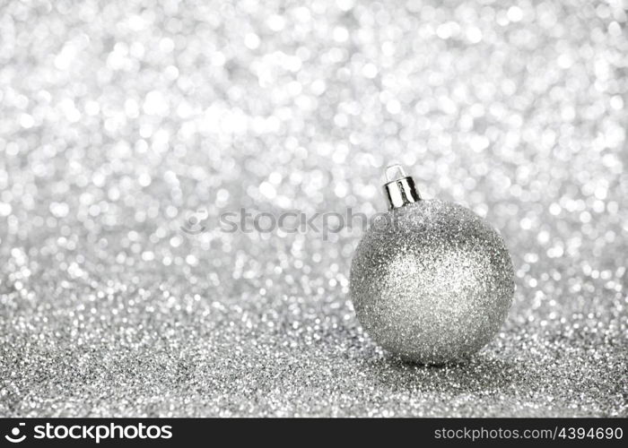 Silver christmas ball on glitter background with copy space