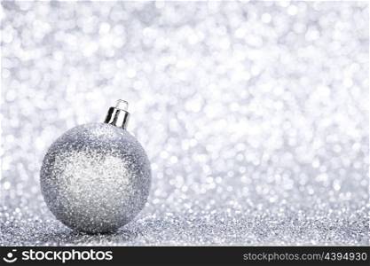Silver christmas ball on glitter background with copy space