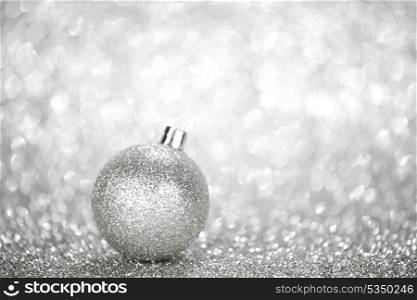 Silver christmas ball on glitter background with copy space