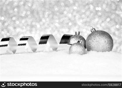 Silver Christmas decorations on snow close-up