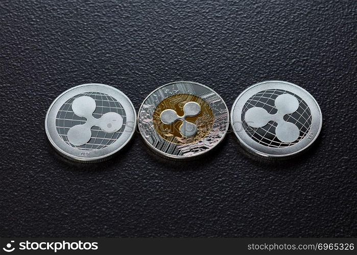 Silver coins are ripple. The front and back of the coins are represented on a dark background. Virtual money concept. Top view. Three silver ripplecoins isolated on a dark background. Cryptocurrency and blockchain trading concept. Top view