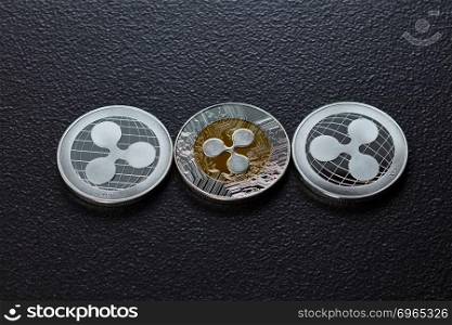 Silver coins are ripple. The front and back of the coins are represented on a dark background. Virtual money concept. Top view. Three silver ripplecoins isolated on a dark background. Cryptocurrency and blockchain trading concept. Top view