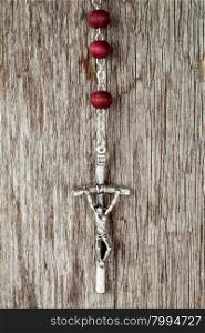 Silver cross crucifix hanging on old wooden background