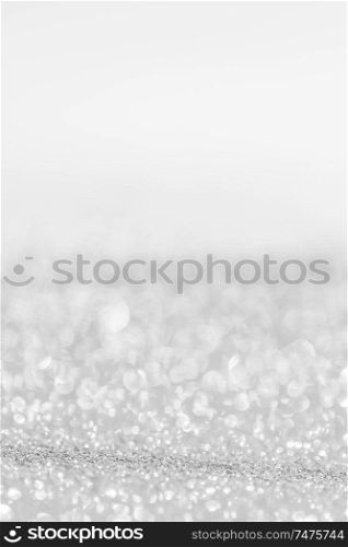 Silver festive glitter background with defocused lights. Festive glitter background