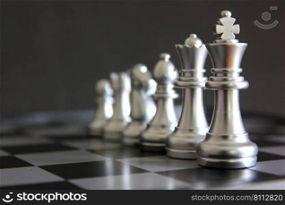 silver king chess with chess pieces on chess board isolate on black background