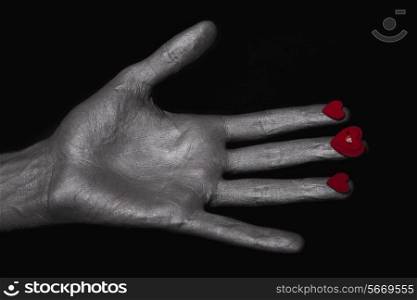silver man&rsquo;s hand with a heart symbol on his fingers