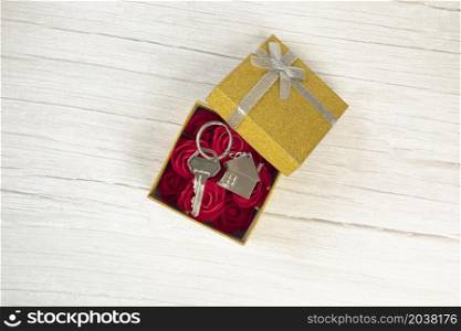 Silver new keys in golden sparkling gift box for buying new house, present, real estate concept top view, copy space space for text. Silver new keys in golden sparkling gift box for buying new house, present, real estate concept top view, copy space