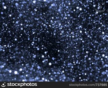 Silver overlay background of glittering lights with bokeh effect.