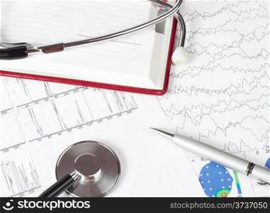silver pen and stethoscope lying on a chart