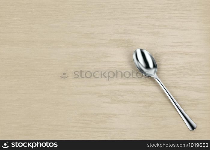 Silver spoon on wooden table, top view