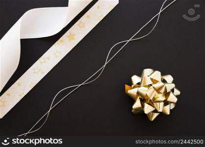 silver string white star shape ribbon golden bow black background