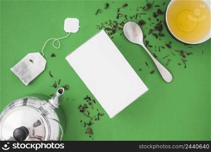 silver teapot spoon herbal tea green background