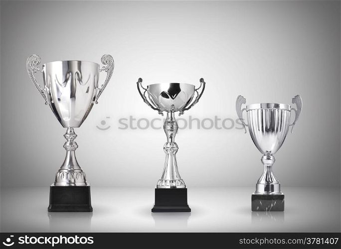 Silver trophies on gray background