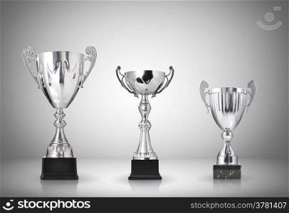 Silver trophies on gray background