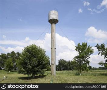Silver Water Tower among green grass and trees.. Silver Water Tower among green grass and trees