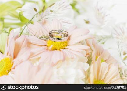 silver wedding rings pink gerbera flower bouquet