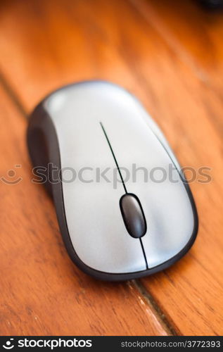 Silver wireless mouse on wood table