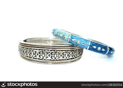 Silvery bracelet with ornament and blue and cyan bracelet with drops on the white.