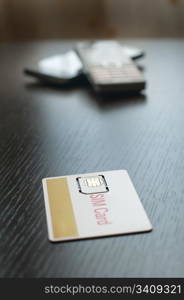 SIM card and mobile phone on table