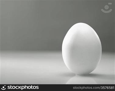 Simple as... White egg over desk with reflection and shadow