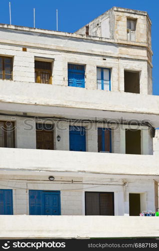 Simple building with windows, doors and balconies in the style of constructivism on Malta