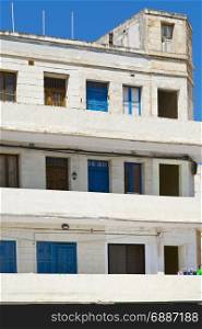 Simple building with windows, doors and balconies in the style of constructivism on Malta