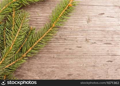 simple Christmas background with fir branches on wooden board, empty space for text