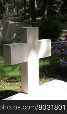 Simple plain cross gravestone in sunlight