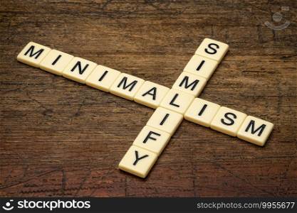 simplify and minimalism crossword in ivory letters against rustic, weathered wood, simplicity, declutter and lifestyle concept