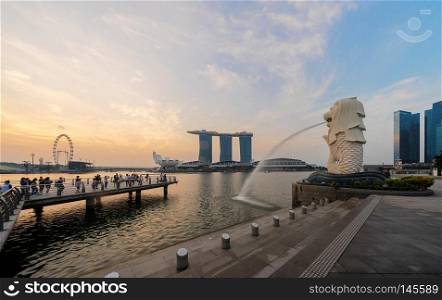 Singapore City - July 29, 2018   Merlion and Marina Bay Sands at sunrise with Singapore Flyer and twilight sky.