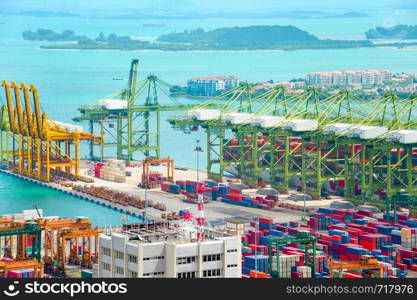 Singapore commercial port aerial view, freight cranes and containers at pier, islands and ships in background