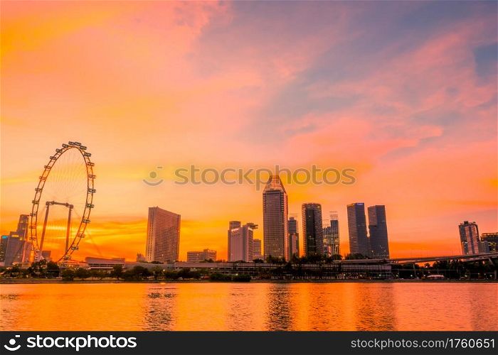 Singapore. Downtown with Ferris wheel and skyscrapers. The golden hour of sunset. Sunset over Singapore and Ferris Wheel
