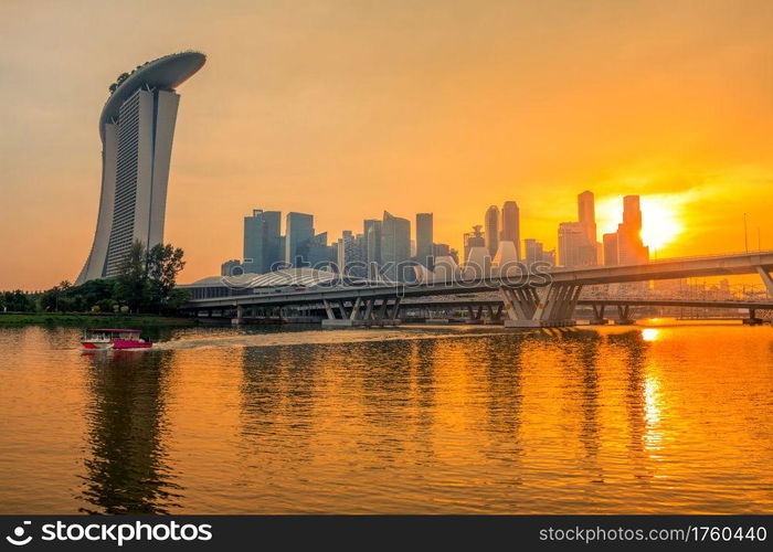 Singapore downtown with Sand Hotel, skyscrapers and two bridges. Golden sunset and beautiful night lighting. Golden Sunset over Singapore Downtown