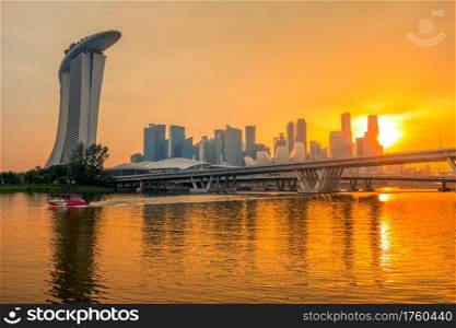 Singapore downtown with Sand Hotel, skyscrapers and two bridges. Golden sunset and beautiful night lighting. Golden Sunset over Singapore Downtown